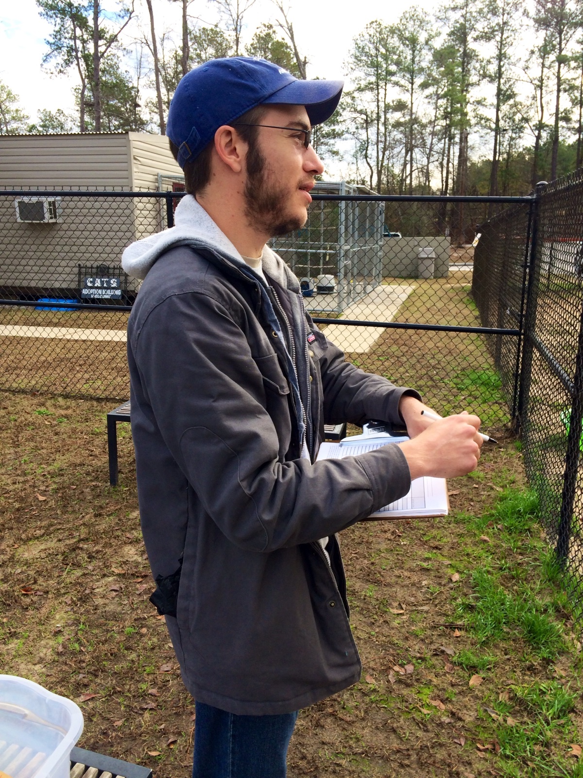 Canine Coach Chris Newell takes notes on the dogs during their play session. These observations help FOTAS and the shelter staff to assess animals and their adoptability.