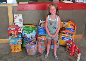 Seven-year-old Marli Cook with the donations her guests brought to her birthday party.