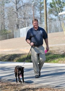 Bobby Arthurs, the chief enforcement officer and ACAS manager, walks a shelter dog.